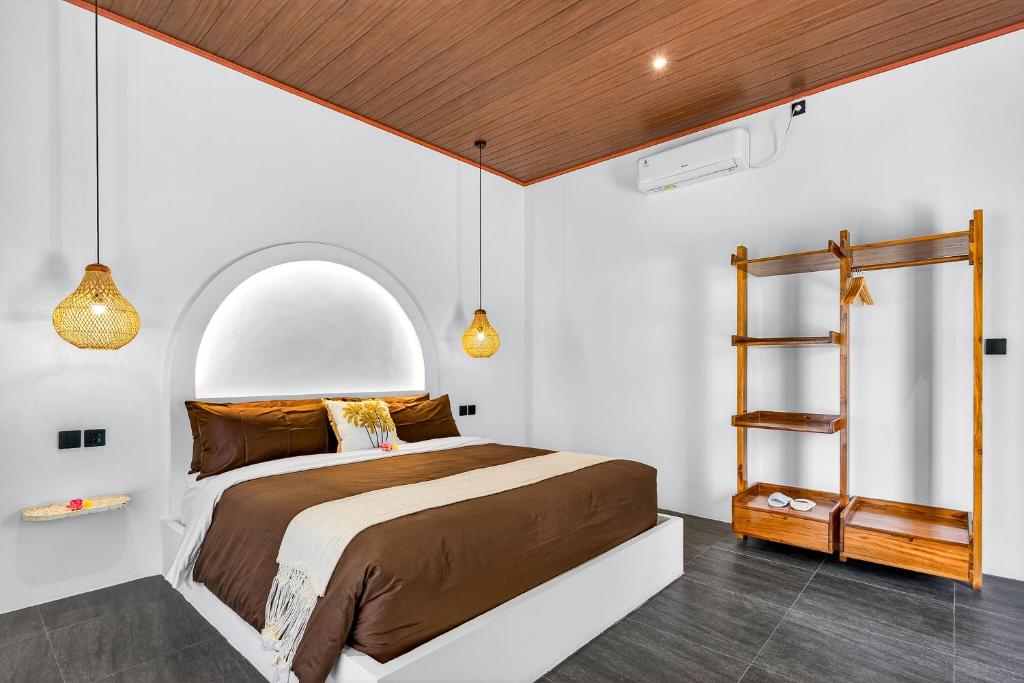 a bedroom with a bed with an arched window at Arch Penida by Bali Cabin in Nusa Penida