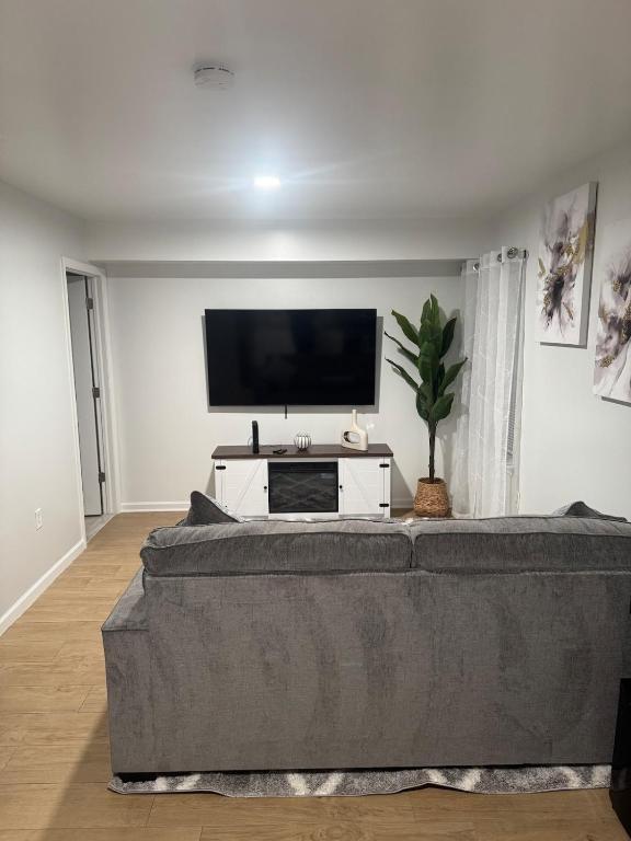 a living room with a couch and a flat screen tv at Chic & Comfy Apartment in Elizabethport