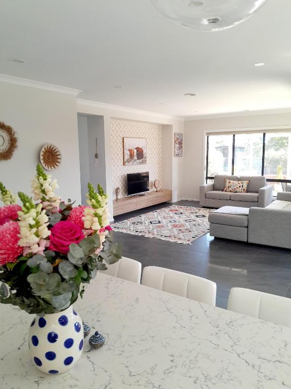 a living room with a vase of flowers on a table at Luxury House Boho Seaside in Cowes