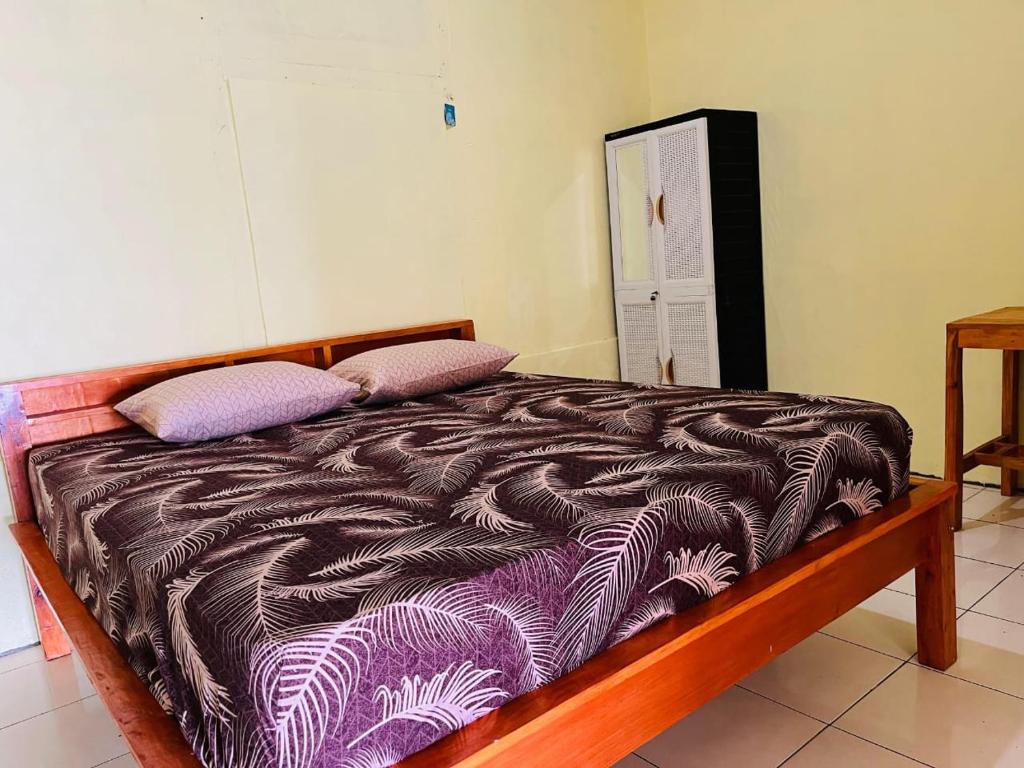 a bed with two pillows on it in a room at Bunaken Scuba Guest House in Bunaken