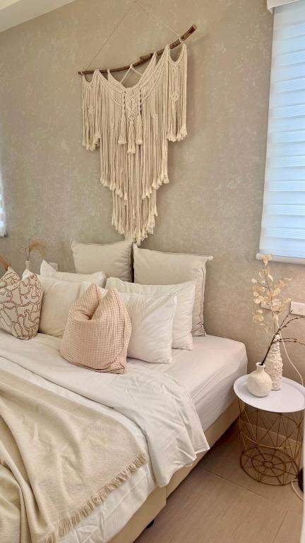 a bedroom with a bed with white pillows and a wall at Burano Yellow Villa in Hengchun South Gate