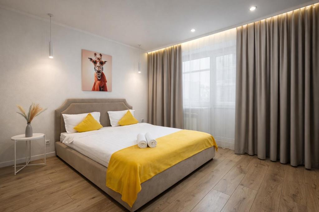 a bedroom with a bed with a yellow blanket on it at Аульбекова 120 in Kokshetau
