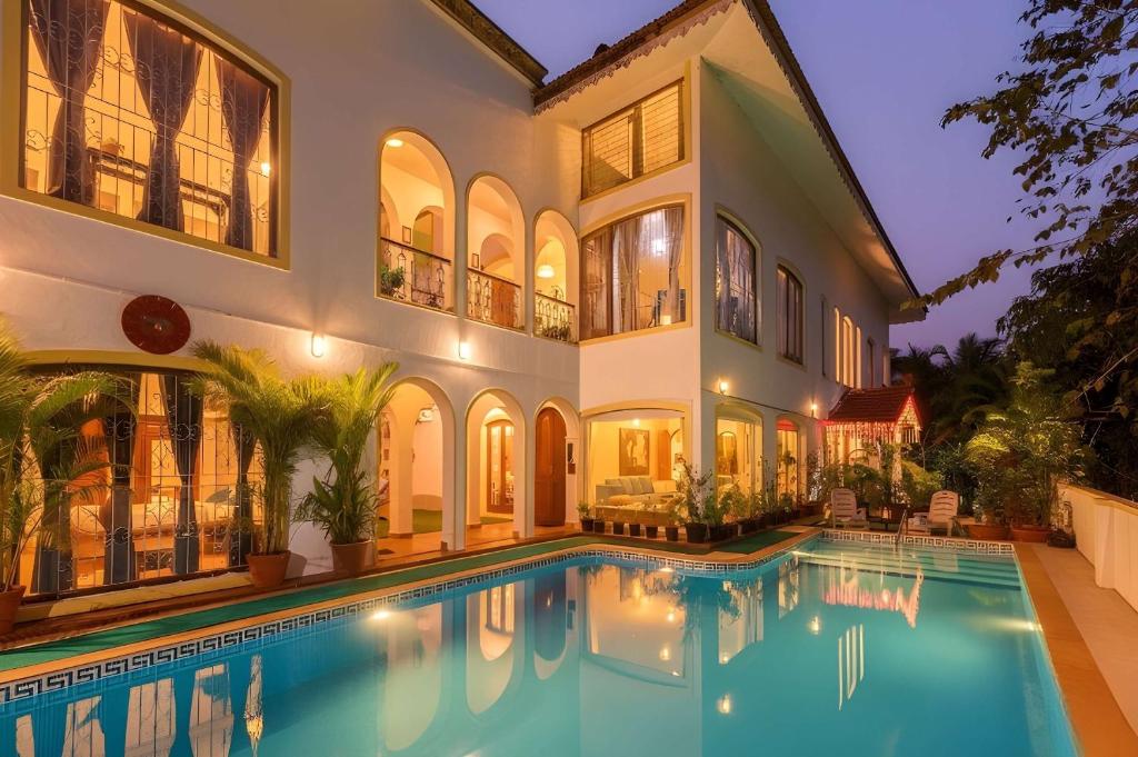 an exterior view of a house with a swimming pool at Casa Do Amor by VEO - Part of StayVista in Sangolda