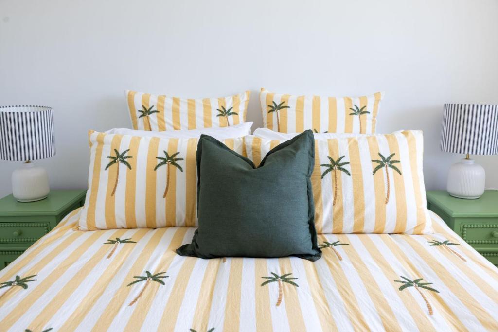 a bed with a pillow and two green night stands at 2-45 Beech Street in Evans Head
