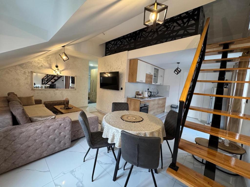 a living room and kitchen with a table and a couch at Apartment Star 2 Ledine in Beograd