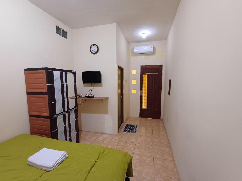 a bedroom with a green bed and a hallway at Irma Guest House Syariah in Temenggungan
