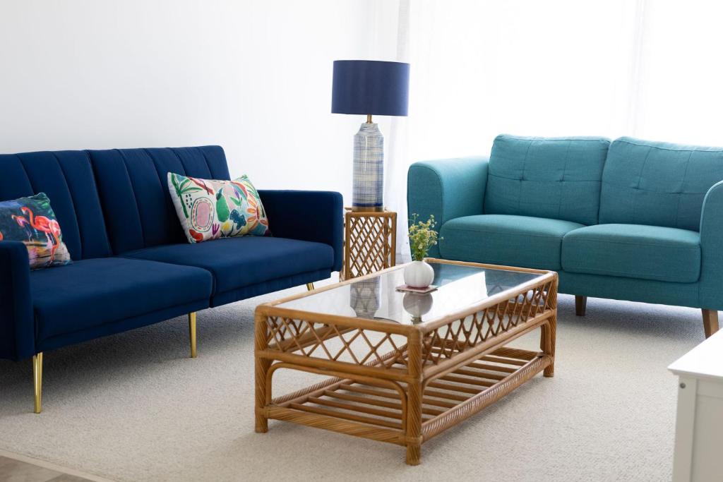 a living room with two blue couches and a coffee table at 3-45 Beech Street in Evans Head