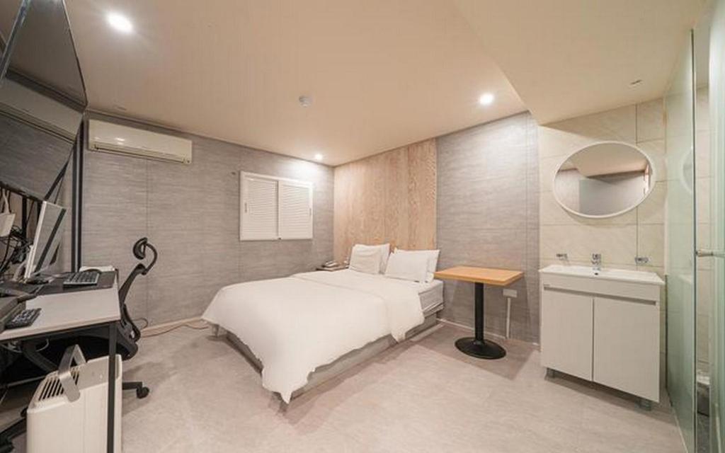 a bedroom with a bed and a desk and a sink at ZaZaHOTEL in Sosa