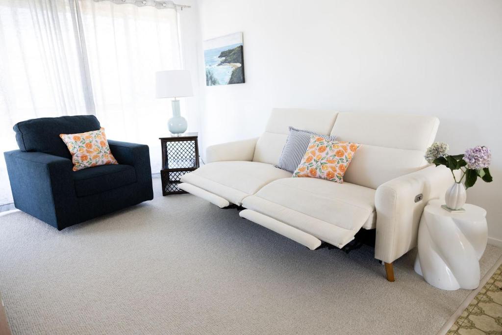 a living room with a white couch and a blue chair at 4-45 Beech Street in Evans Head