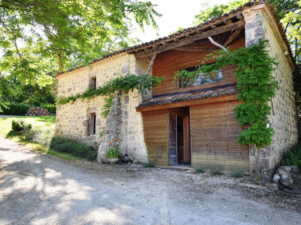 Saint-Caprais-de-LermにあるRustic Castle in Bon-Encontre with Terraceの蔦の古い石造りの家