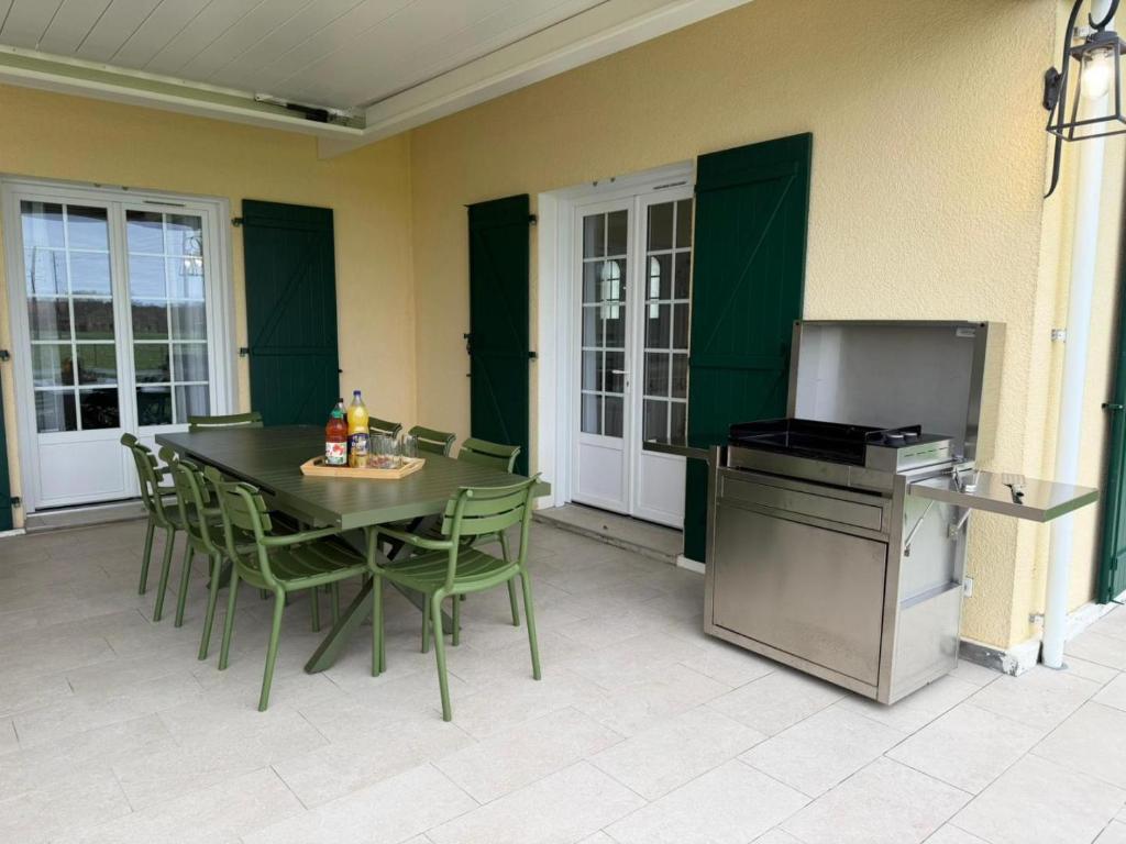 a patio with a table and chairs and a refrigerator at Gîte du nouguès in Garrey