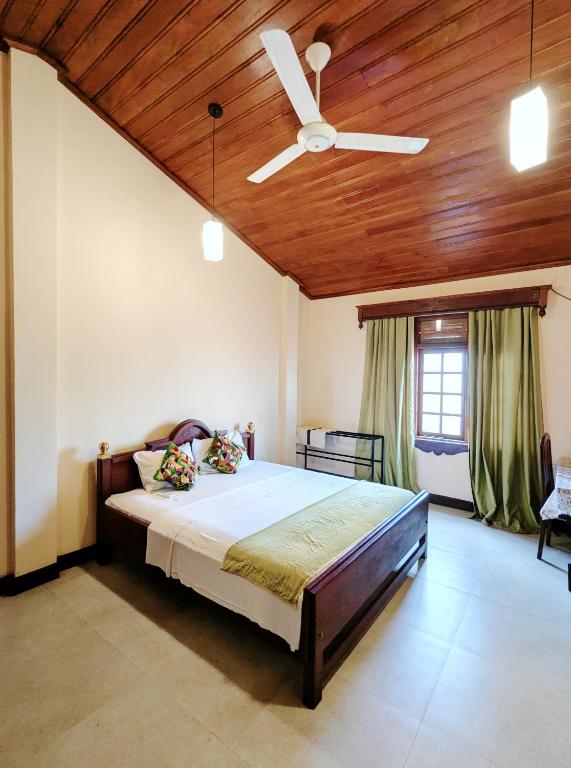 a bedroom with a bed with a ceiling fan at Hill Crest Mansion in Kandy