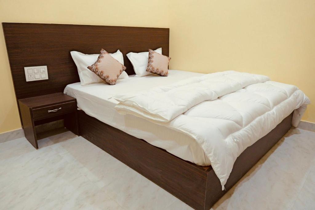 a large bed with white sheets and pillows on it at Hotel Ramkrishna Stay in Khajurāho