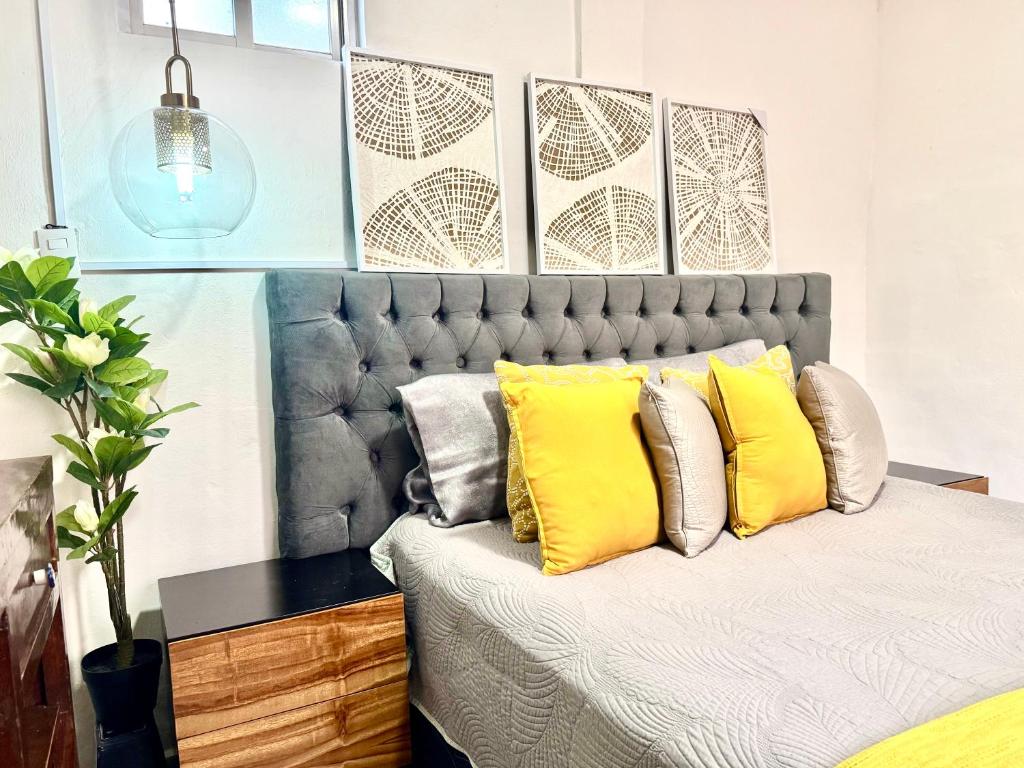 a bedroom with a large bed with yellow pillows at CASA YON SAN JUAN escapada en pareja in Cuautitlán Izcalli