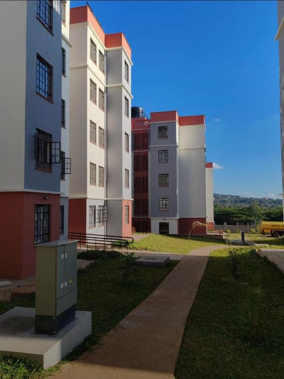 a group of tall buildings with a sidewalk and grass at Haven Nest in Machakos