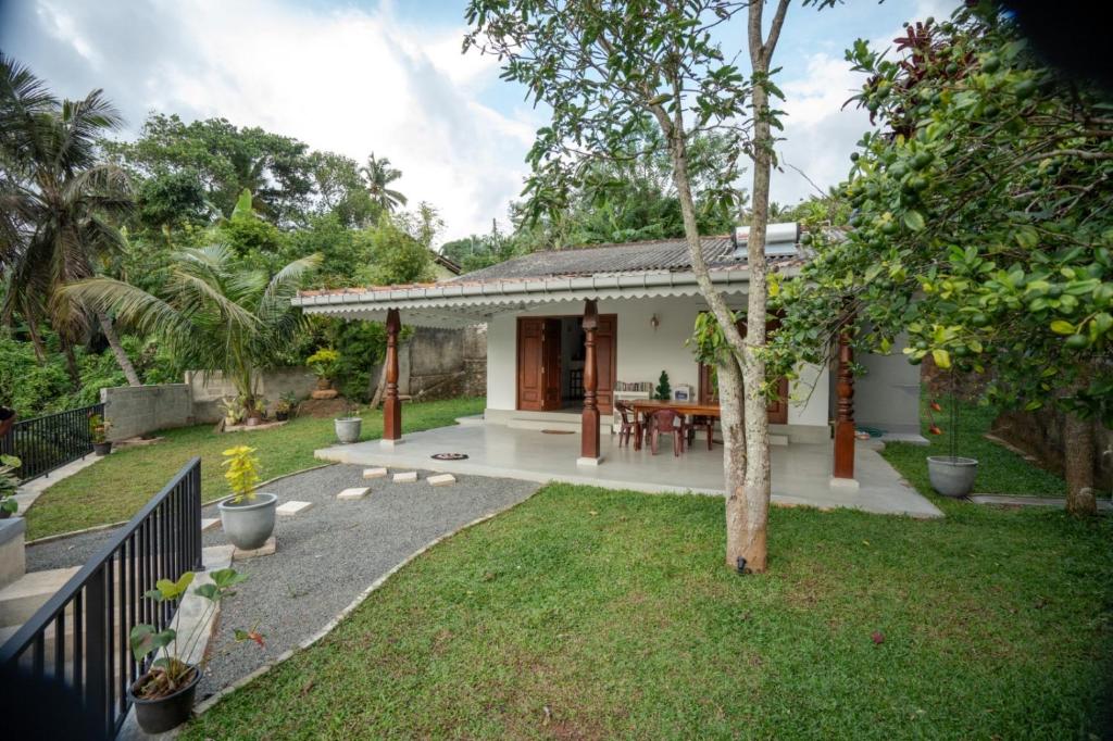 a small house with a patio and a yard at Villa Paranawatta in Unawatuna