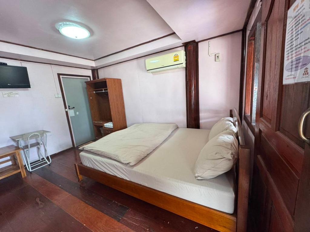 a small bed in a small room with a table at Newhome RESORT in Ban Sawang