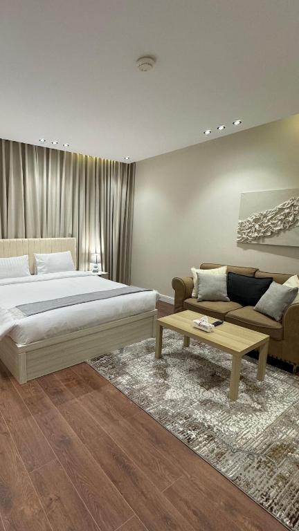 a bedroom with a bed and a couch and a table at شقة حي الوزارات in Riyadh