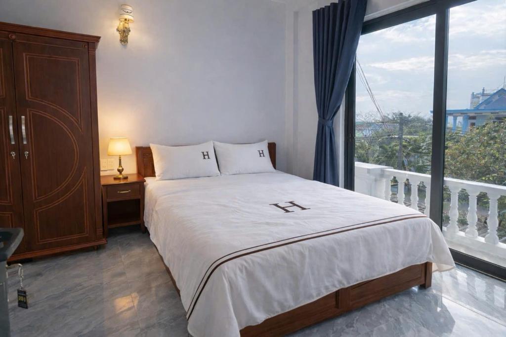 a bedroom with a bed and a large window at Anh Dung Homestay in Ga Thừa Lưu