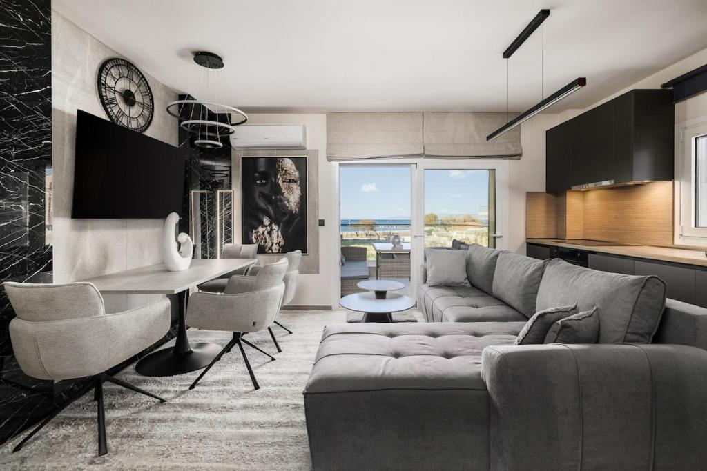a living room with a couch and a table at Blazer suite on the sea in Neoi Epivates