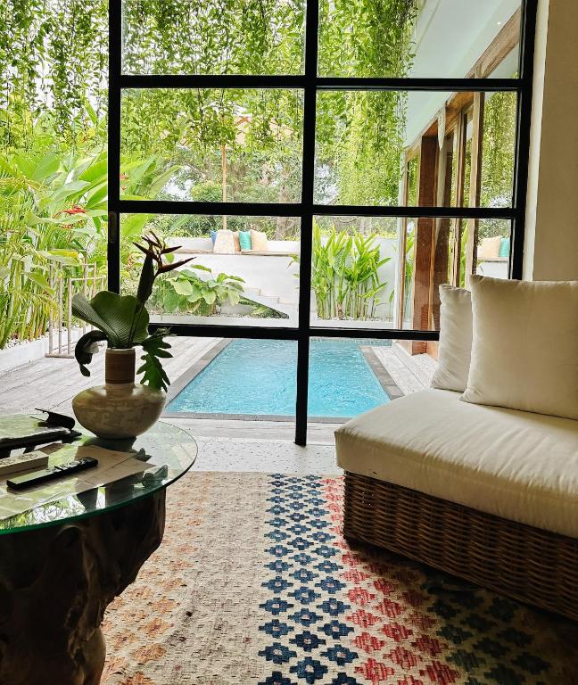 a living room with a couch and a table and a pool at Santai Villas in Nusa Lembongan