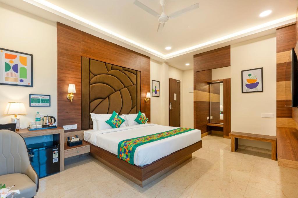 a bedroom with a bed and a desk and a chair at Treebo Premium Pine Tree Courtyard in Chennai