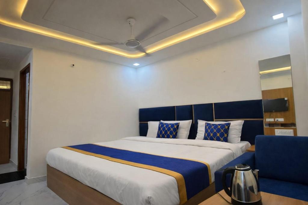 a bedroom with a large bed with a blue headboard at Hotel Golden Palace in Agra