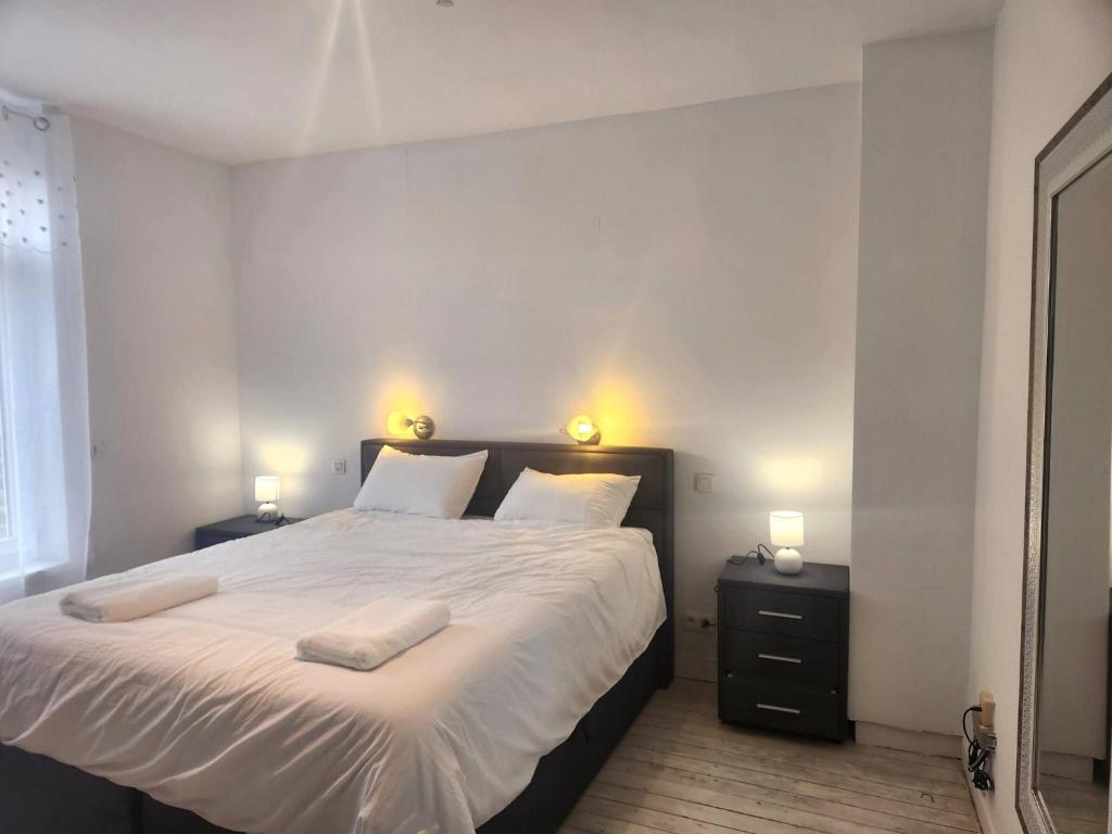 a bedroom with a large bed with two towels on it at Welcome to our Mouscron cocoon in Marcinelle