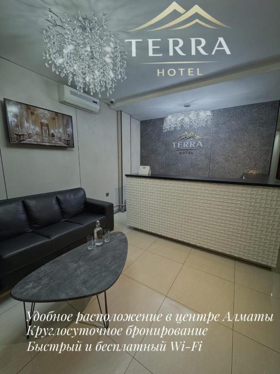a hotel room with a couch and a table at Гостиница TERRA in Almaty