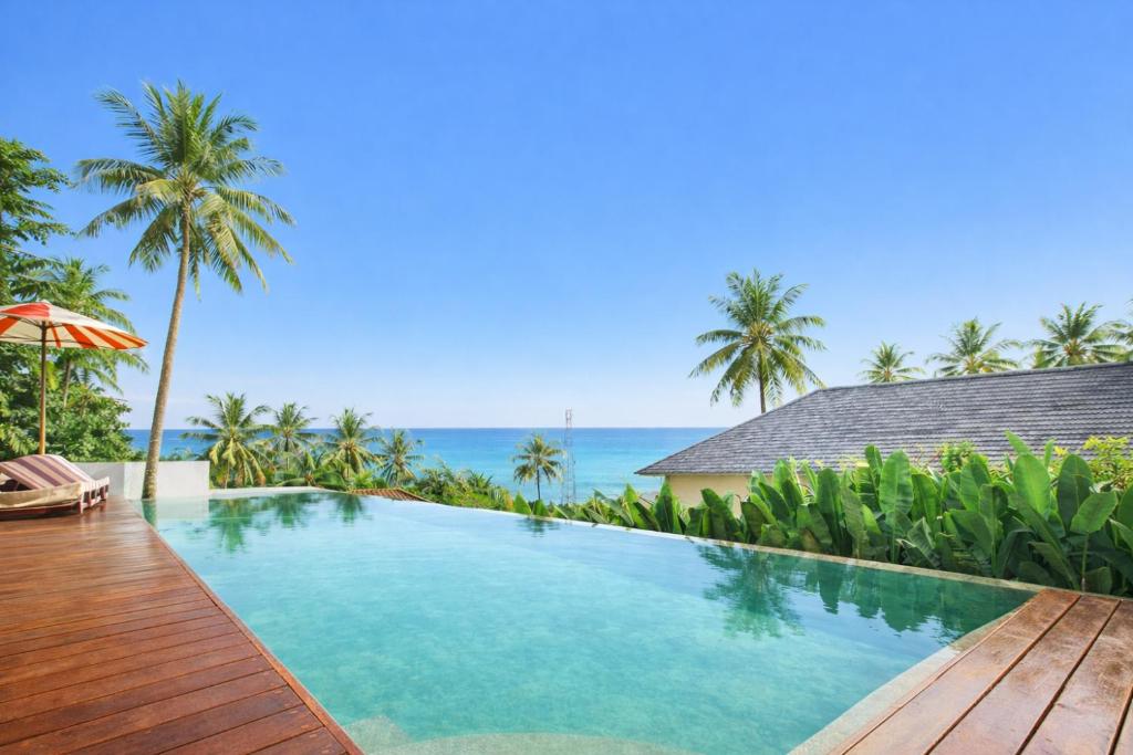 a swimming pool with a view of the ocean at Segara Hill Villa in Senggigi