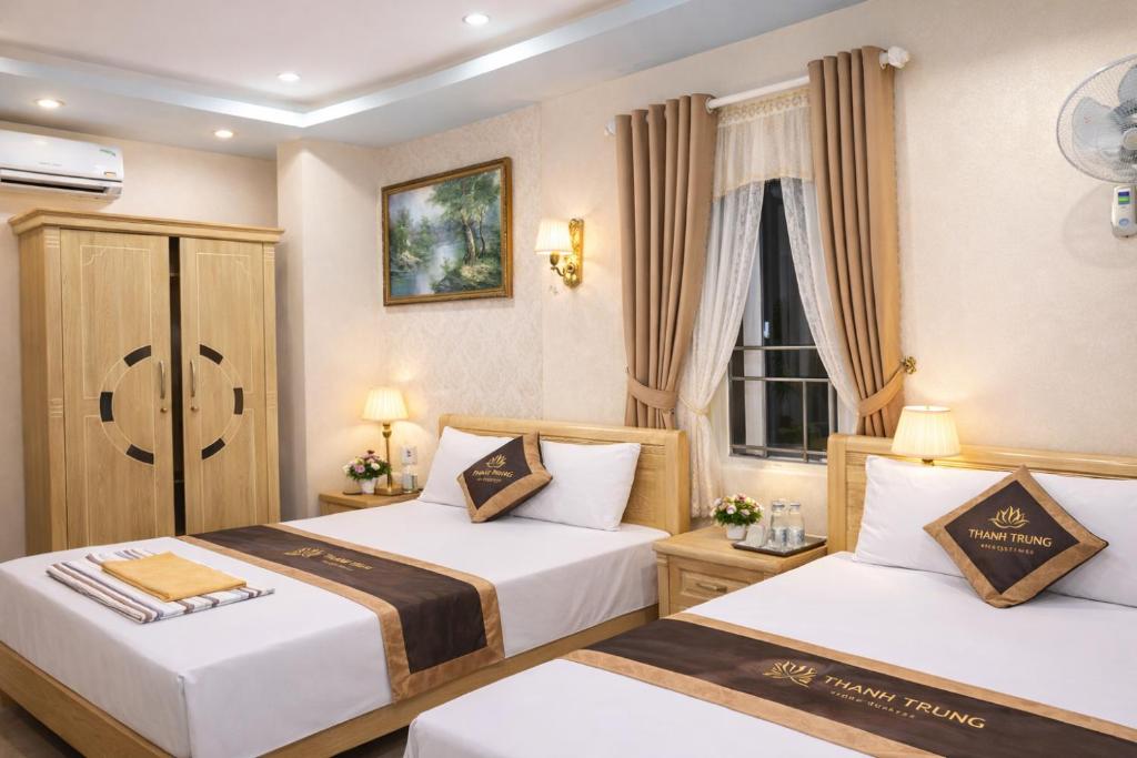 a hotel room with two beds and a window at Thành Trung Motel in Cat Ba