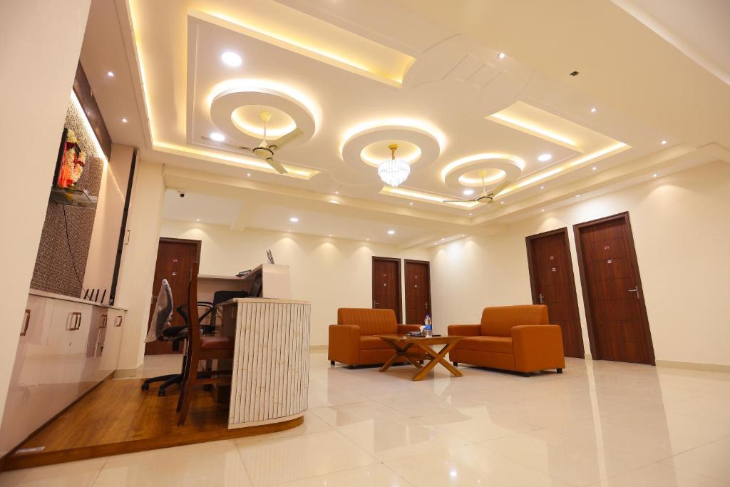 a living room with couches and chairs and a ceiling at S V Grand Inn in Bangalore