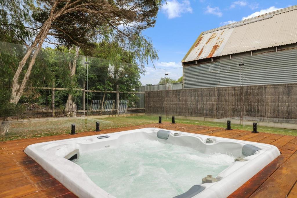 a large white bath tub sitting on top of a yard at The Cape House in Cape Woolamai
