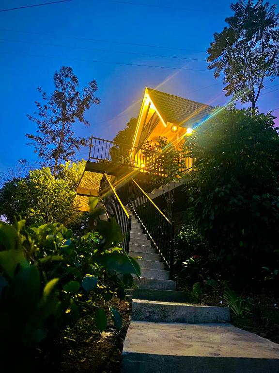 ein Haus mit einer Treppe, die nachts hinaufführt in der Unterkunft Loop Side Cabin in Ella