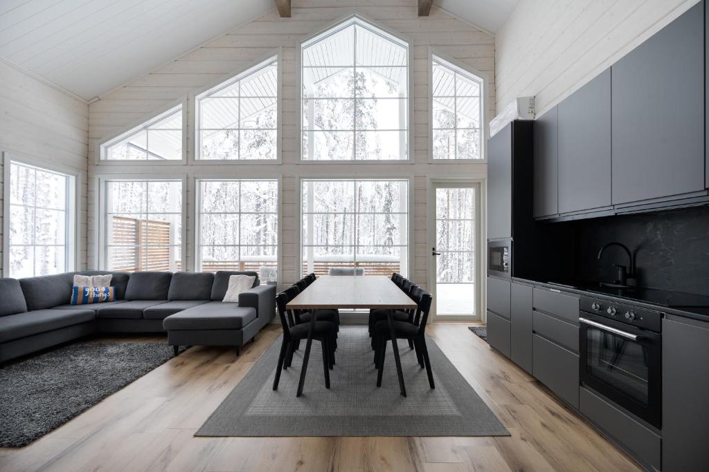 a living room with a table and a couch at Villa Taalontuuli Aurora & Forest Views sleeps 10 in Kittilä