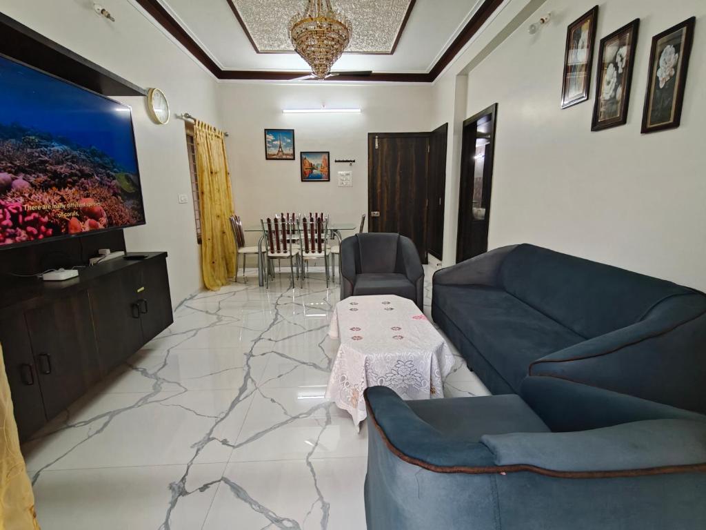 a living room with a couch and a table at Elegant 2 BHK Furnished flat without AC and with AC additional price in Belgaum