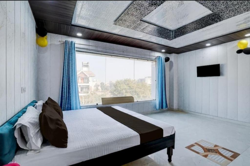 a bedroom with a bed and a large window at Nice hotel in Faridabad