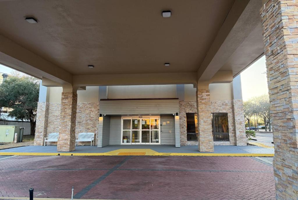 a building with columns and a porch with two benches at Wingate by Wyndham Jacksonville FL in Jacksonville