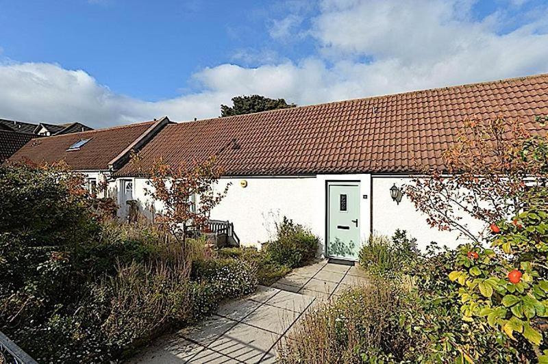 a white house with a red roof at COSY COTTAGE FOR SHARE , Private Double Room, Wifi, Parking, Garden in Edinburgh