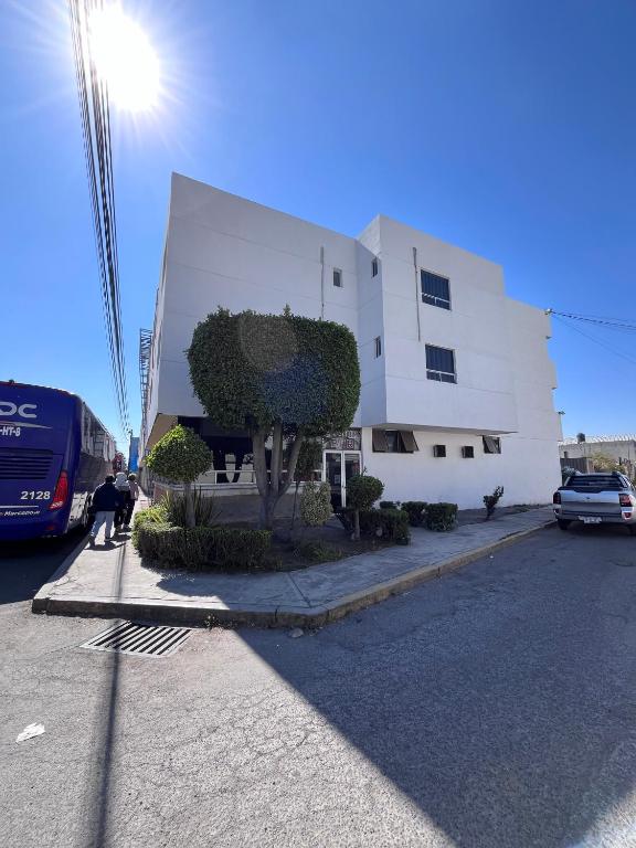 a white building with a tree in front of it at Hotel Granada in Puebla