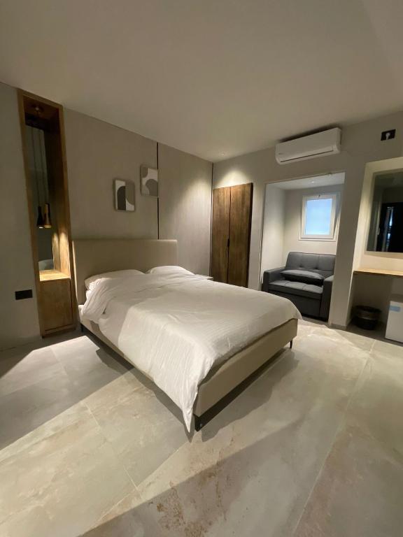 a bedroom with a large white bed and a couch at הוד והדר in Netanya