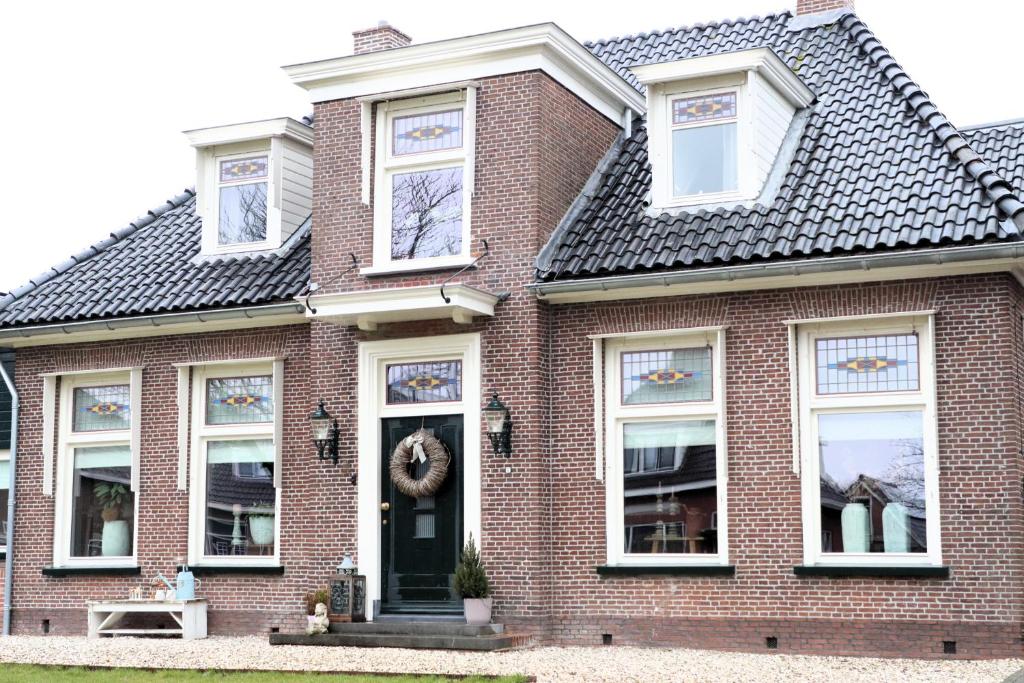 a brick house with a wreath on the door at Huize Sonnevanck in Sexbierum