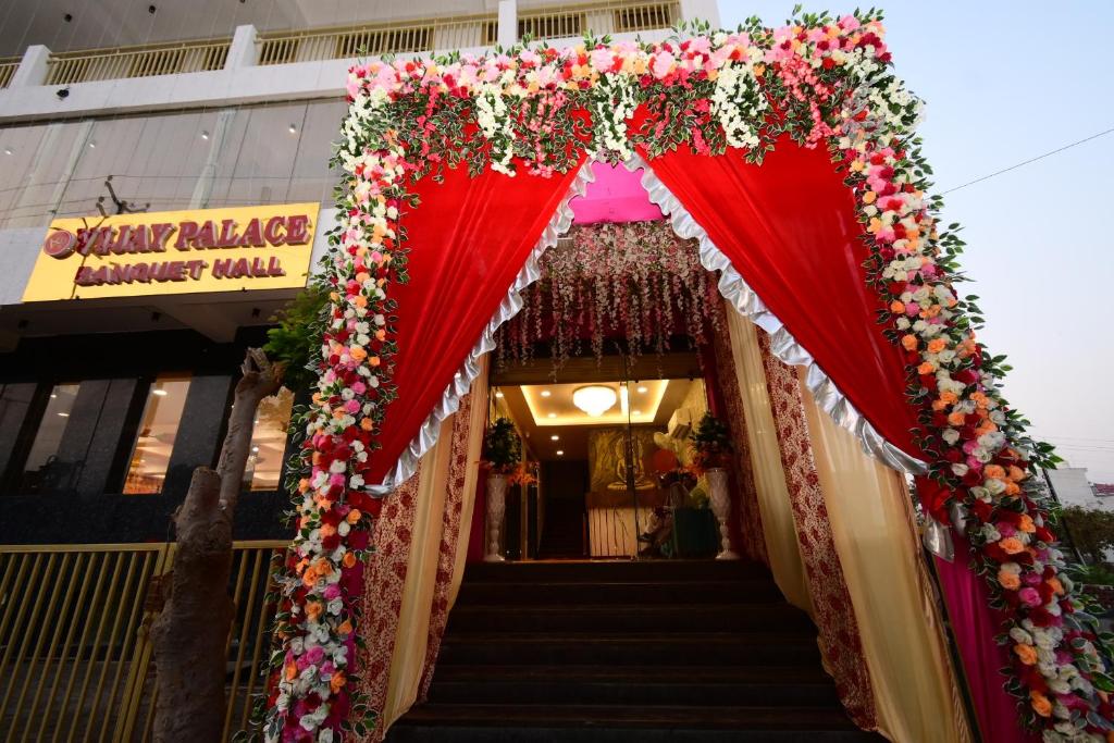 an entrance to a building with a red canopy and flowers at Hotel Vijay Palace in Agra