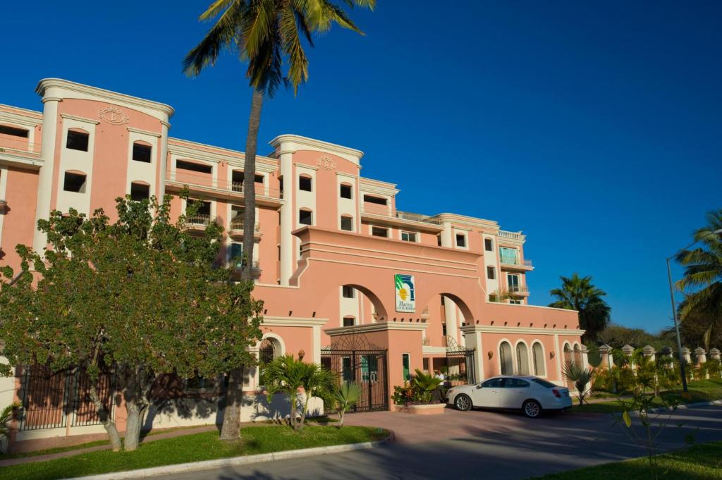 a pink building with a car parked in front of it at Marina Costa Bonita in Mazatlán