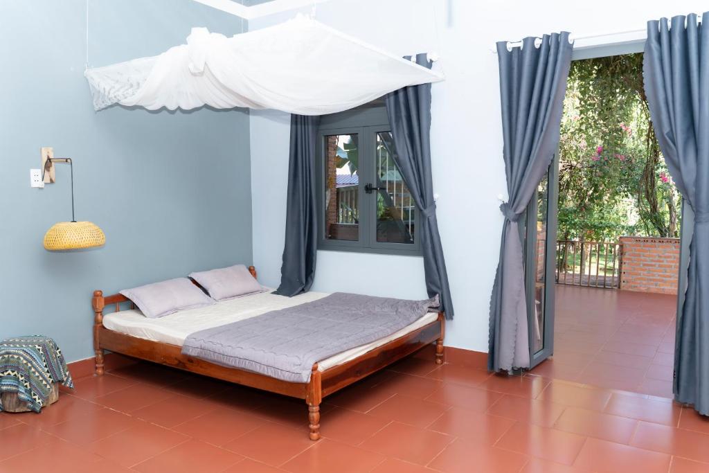 a bed with a canopy in a room with blue walls at The Lazy Farm-Garden Central Room in Mewal
