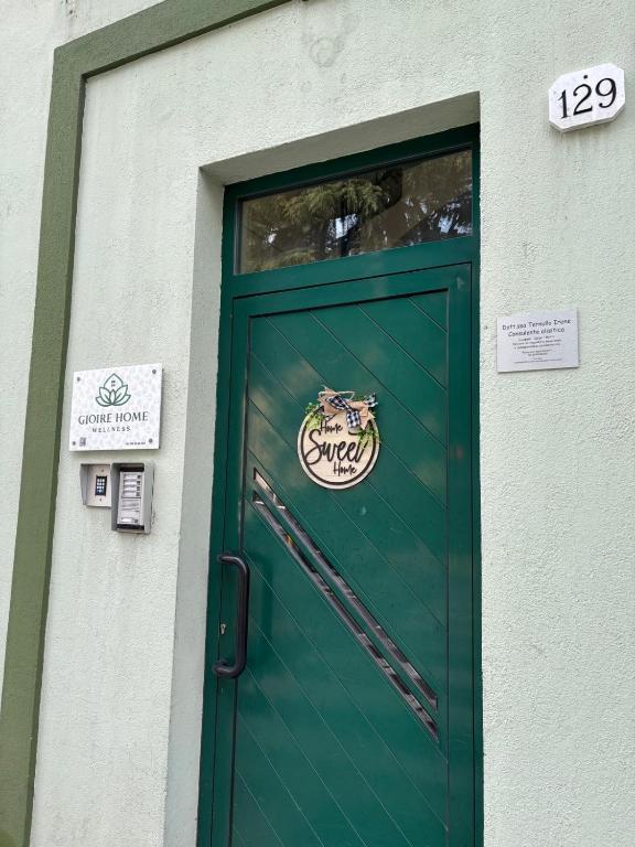 a green door with a sign on top of it at GioIre Home Wellness in Como