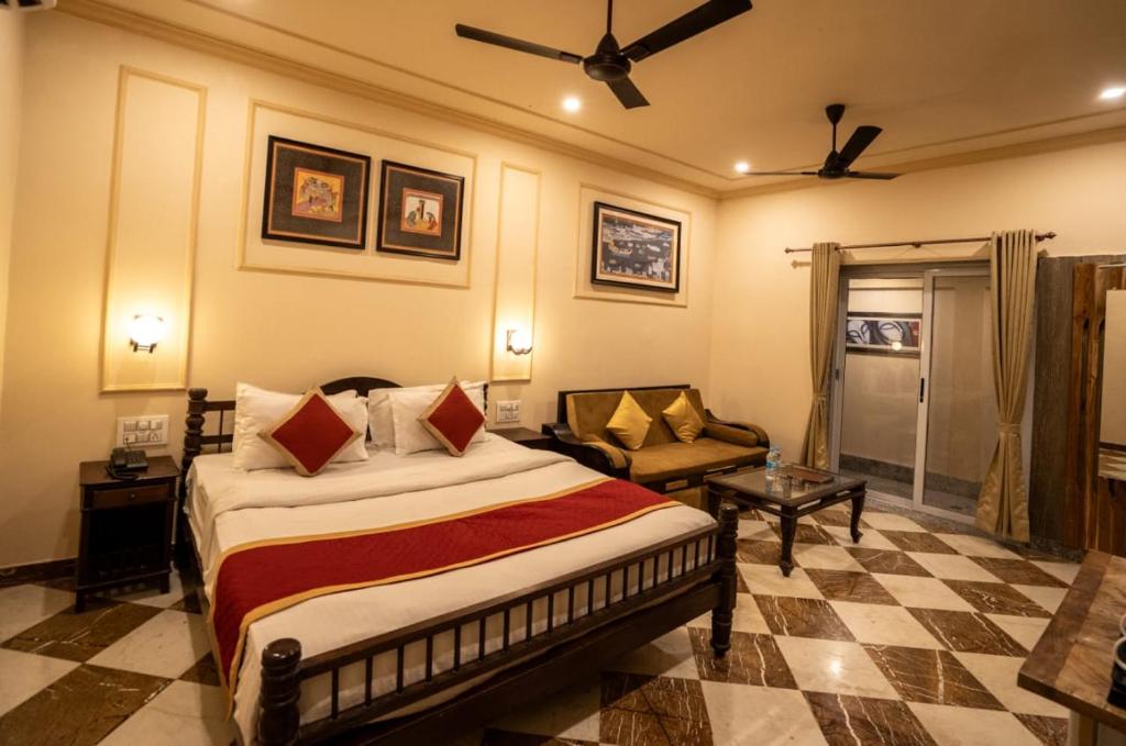 a bedroom with a bed and a couch in a room at aurum villa's kodiyat in Nāi