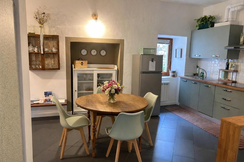 a kitchen with a table and chairs and a refrigerator at LA CASETTA TRA i LAGHI in Omegna