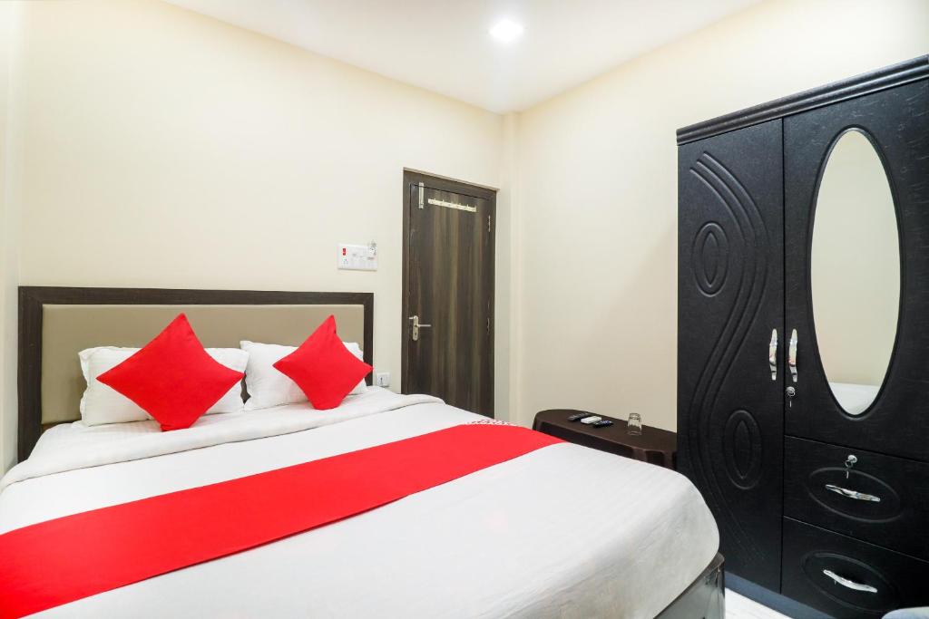 a bedroom with a large bed with red pillows at Hotel O Annie in Rāmgarh