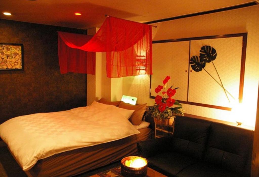 a hotel room with a bed and a couch at ホテルアドレリゾート大人専用 in Sendai